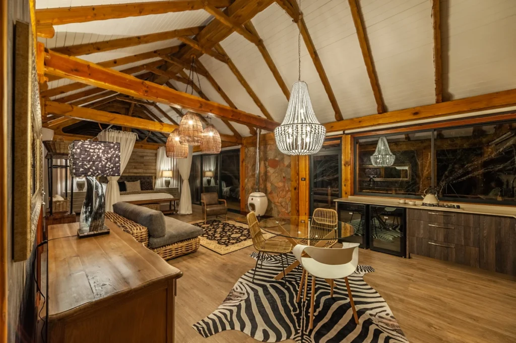 Spacious open-plan luxury suite at Mont Eco Private Nature Reserve featuring natural textures, chandeliers, and African-inspired décor.